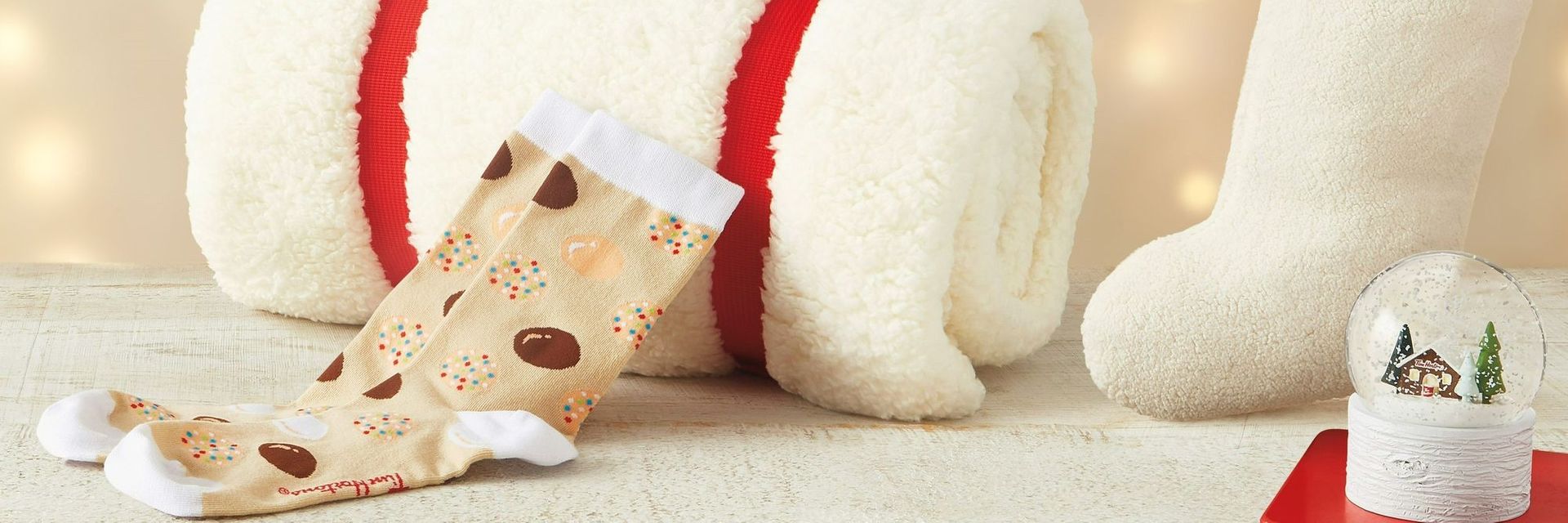 New Tim Hortons Sherpa throw, stocking, snow globe, and festive socks, among the giftable items in the 2022 Tims Holiday Merchandise Collection